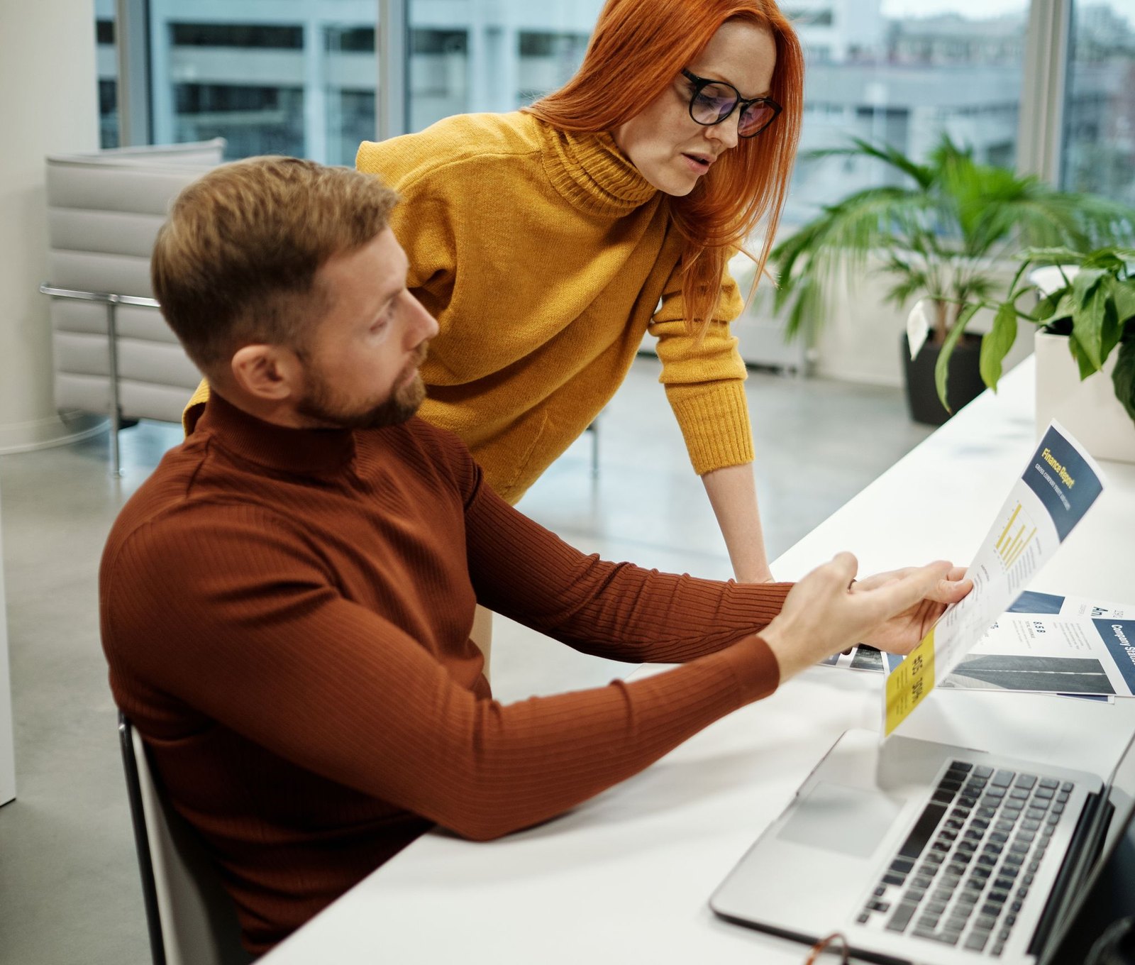 Two recruiters going through a report together at a shared desk